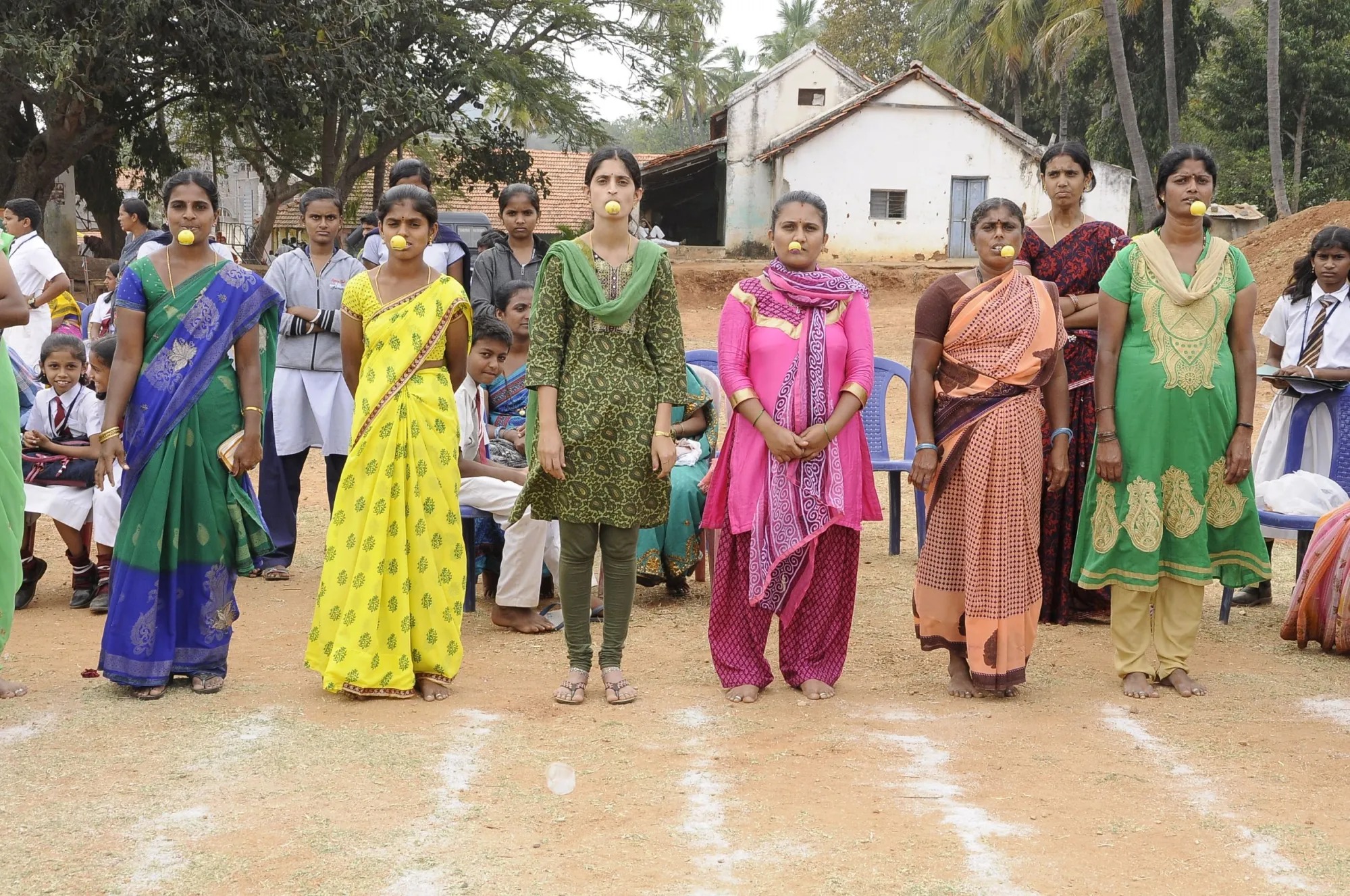 Women and girls participating in a traditional outdoor community activity