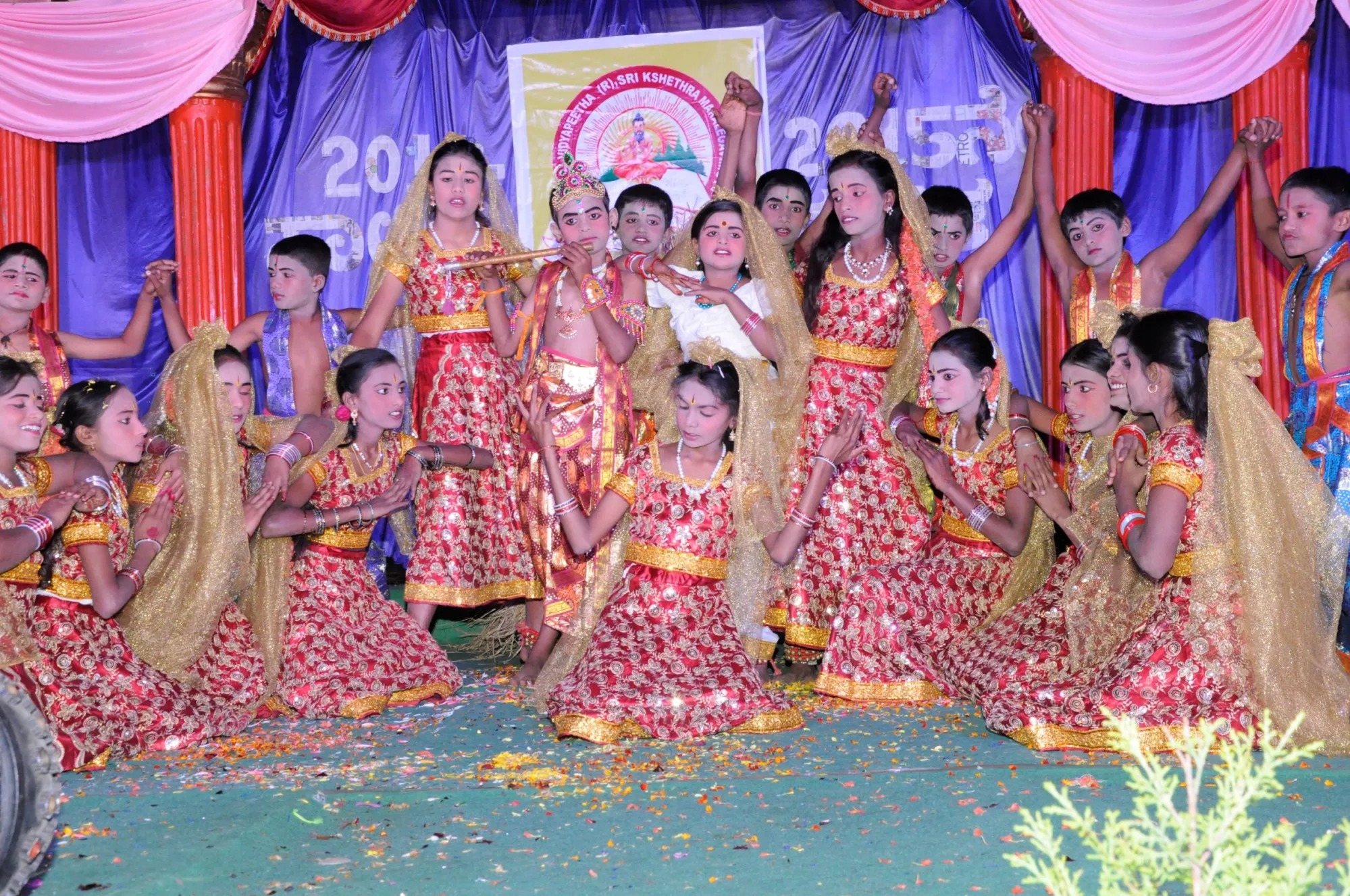 Children performing a dressed cultural scene on a decorated stage