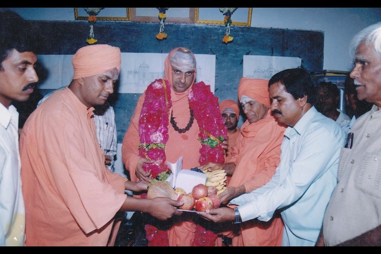 A revered Swamiji receiving a ceremonial welcome with devotees and guests