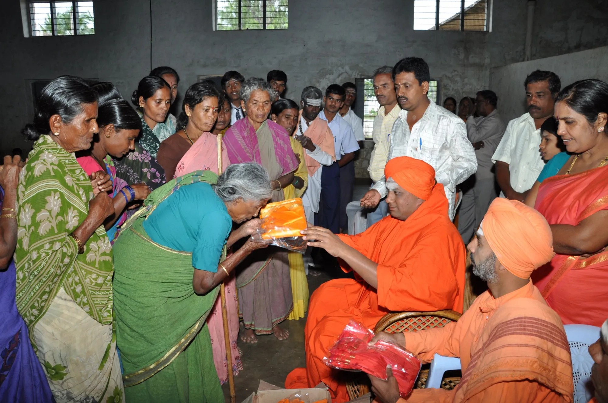 Community member receiving clothing from Swamiji during a service activity